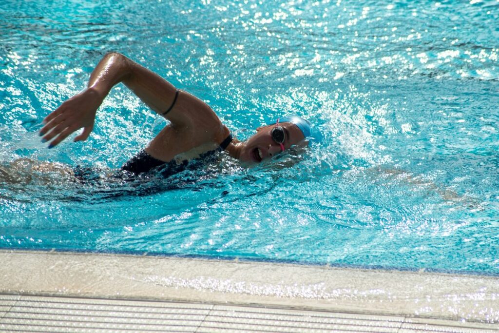Adulto aprendiendo a nadar con instructor en piscina techada